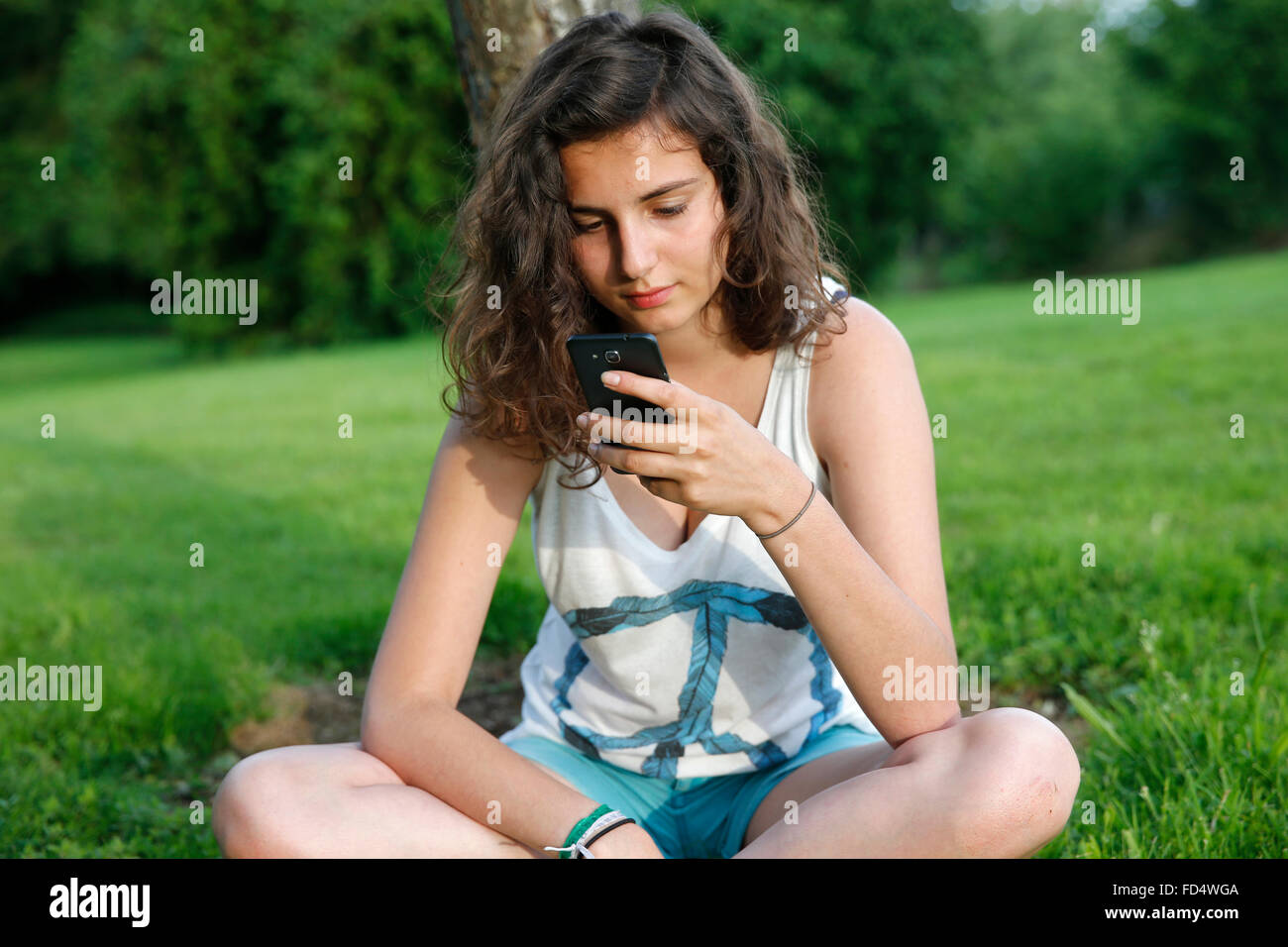 Adolescente utilizzando un telefono cellulare. Foto Stock