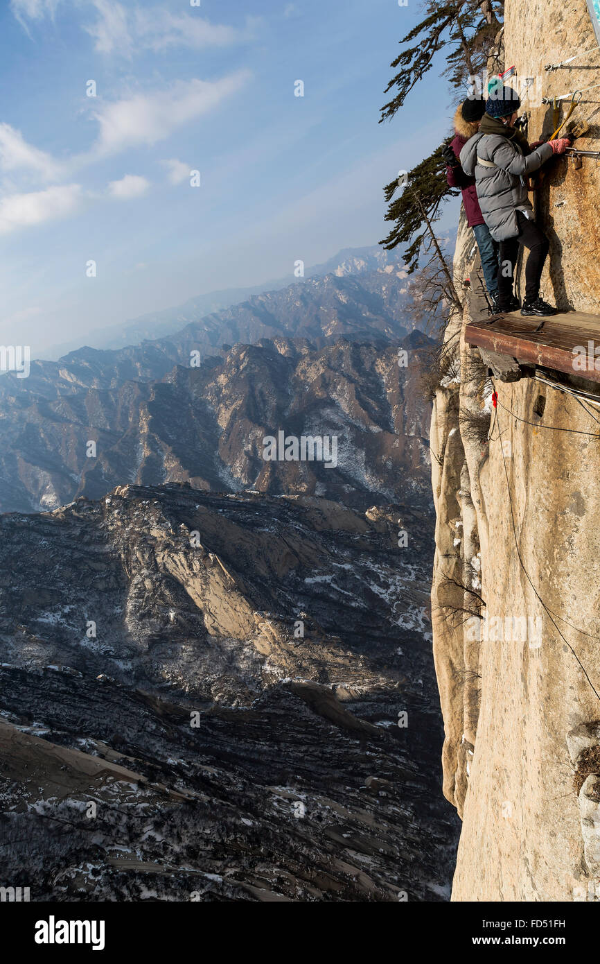 Gli alpinisti camminando sul sentiero di pericolo del monte Hua Shan, Cina. Foto Stock