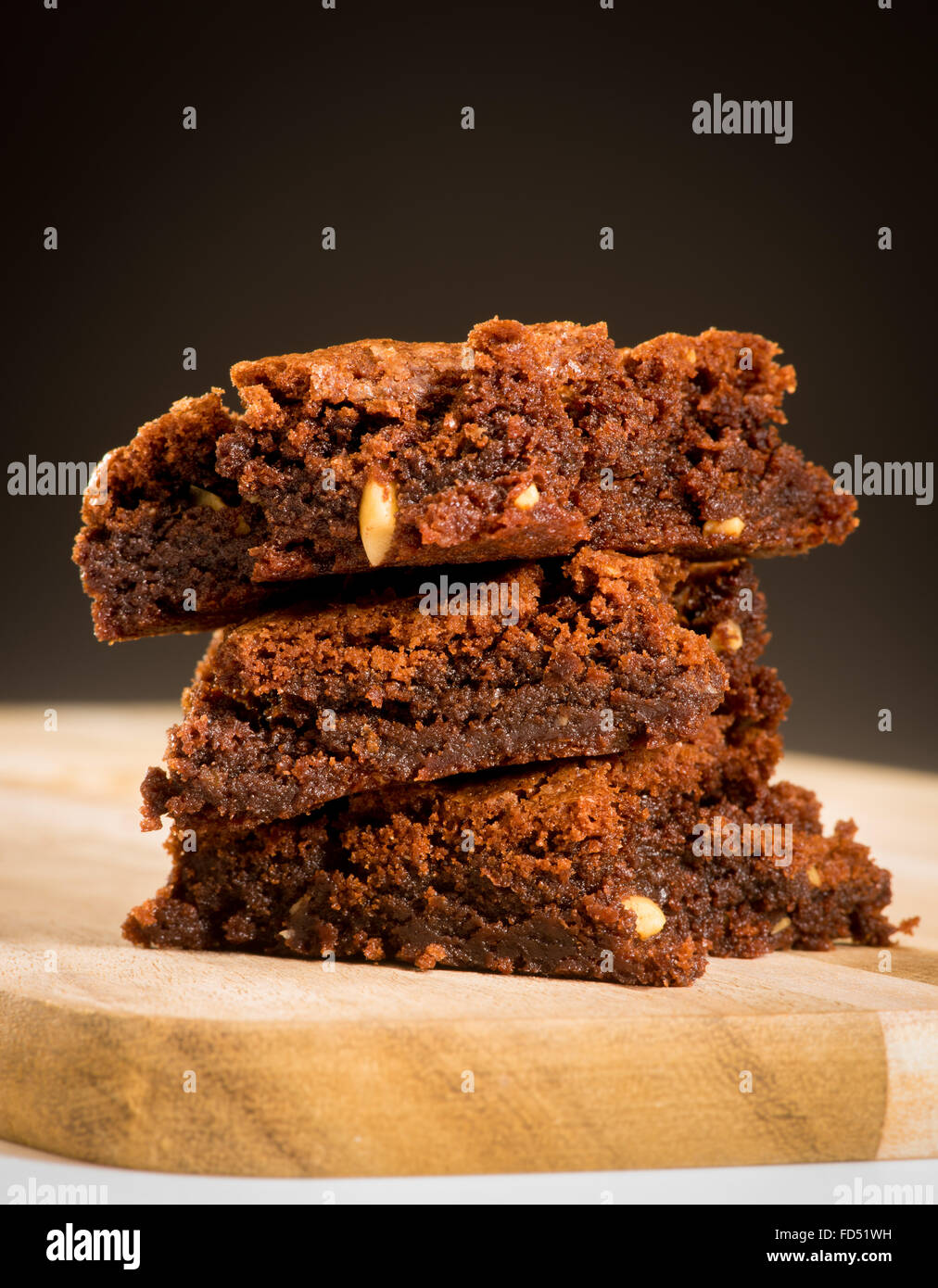 Tre Brownie al cioccolato impilati su una scheda con sfondo scuro Foto Stock
