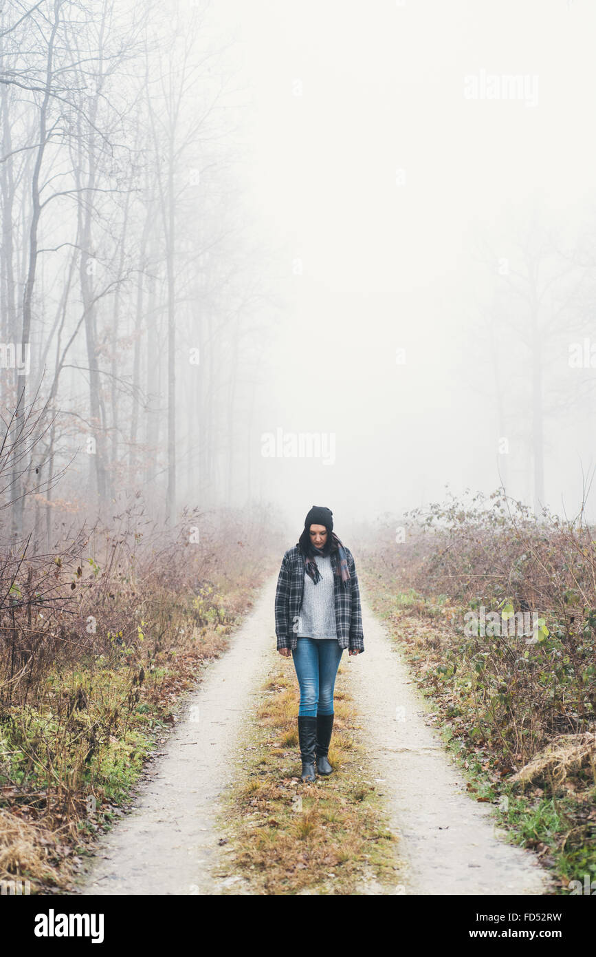 Donna con una passeggiata nel Bosco nebbioso Foto Stock