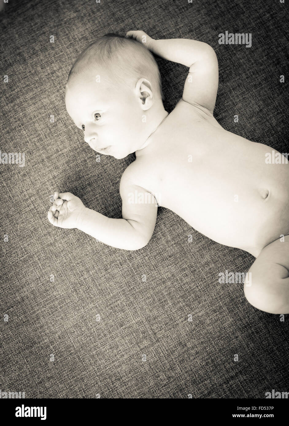 Baby boy solo poche settimane vecchio guarda con occhi spalancati Foto Stock