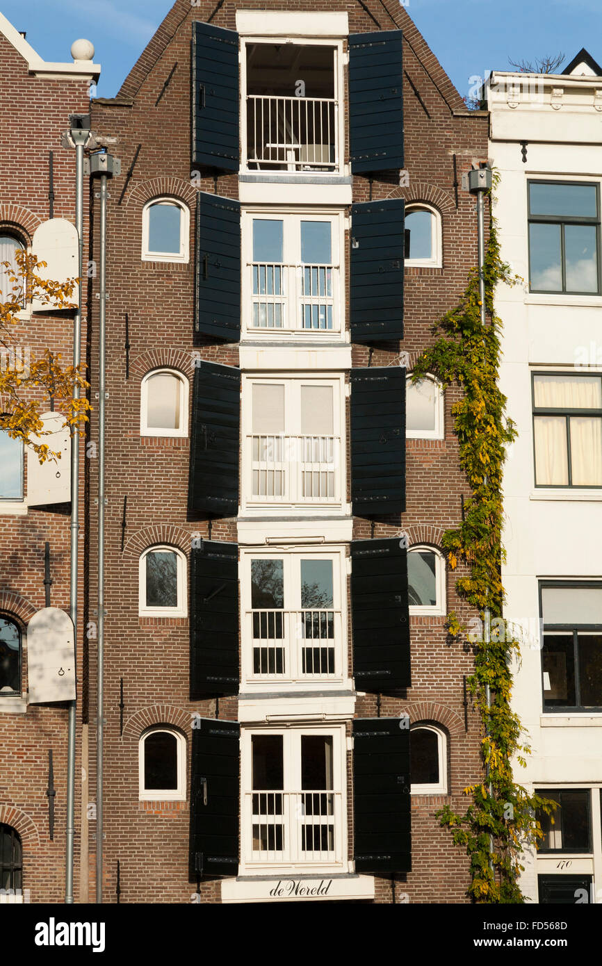 Un alto e sottile casa olandese con il tradizionale legno / persiane di legno alle finestre. Amsterdam, Olanda, Paesi Bassi. (78) Foto Stock