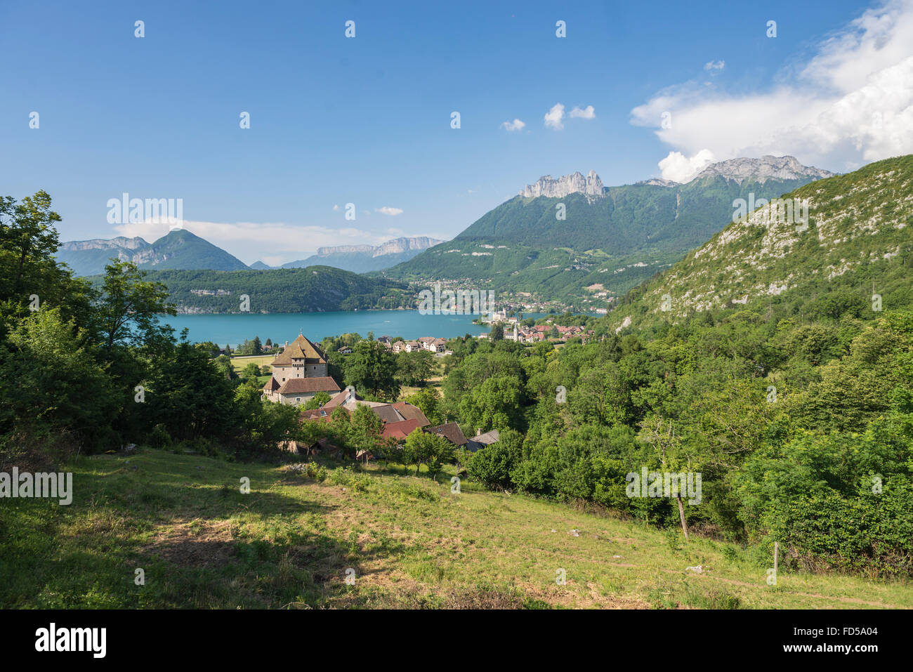 Vista sul borgo e castello di Duingt presso il lago di Annecy con pareti rocciose e verdi foreste della Savoie montagne,Francia Foto Stock