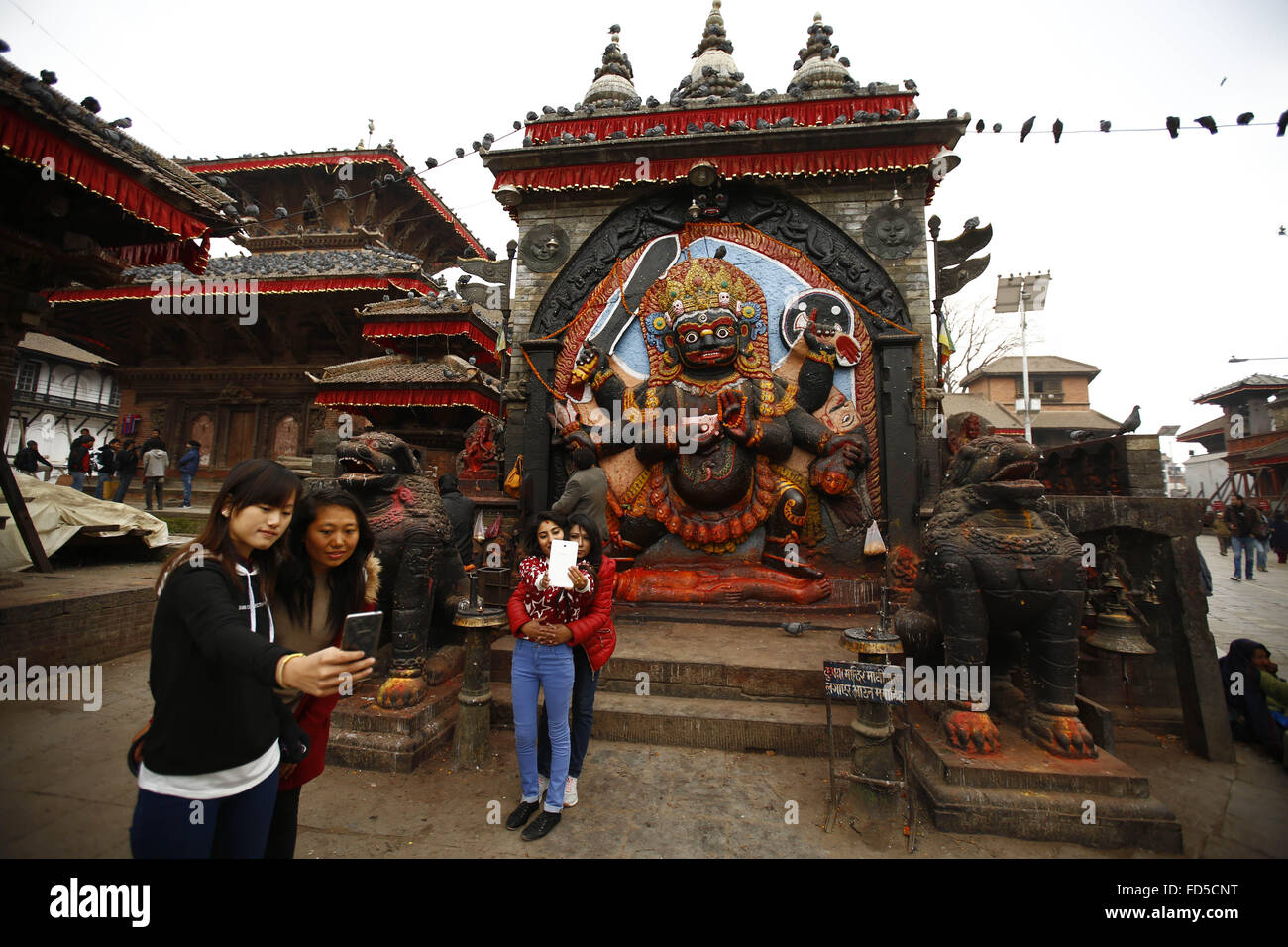 Gen 28, 2016 - Kathmandu, Nepal - due gruppi di donne nepalesi prendere un selfie dal loro smartphone nella parte anteriore di un idolo di Kala Bhairava una divinità Indù in Hanuman Dhoka Square, Kathmandu, Nepal giovedì, 28 gennaio 2016. Il Durbar Square è un'attrazione turistica più popolare e viene elencato nel sito patrimonio mondiale dell'UNESCO. (Credito Immagine: © Skanda Gautam via ZUMA filo) Foto Stock