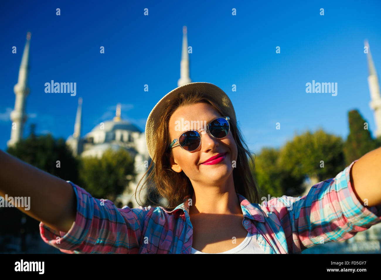 Ragazza in hat rendendo selfie dallo smartphone sullo sfondo della Moschea Blu, Istanbul. Turchia Foto Stock