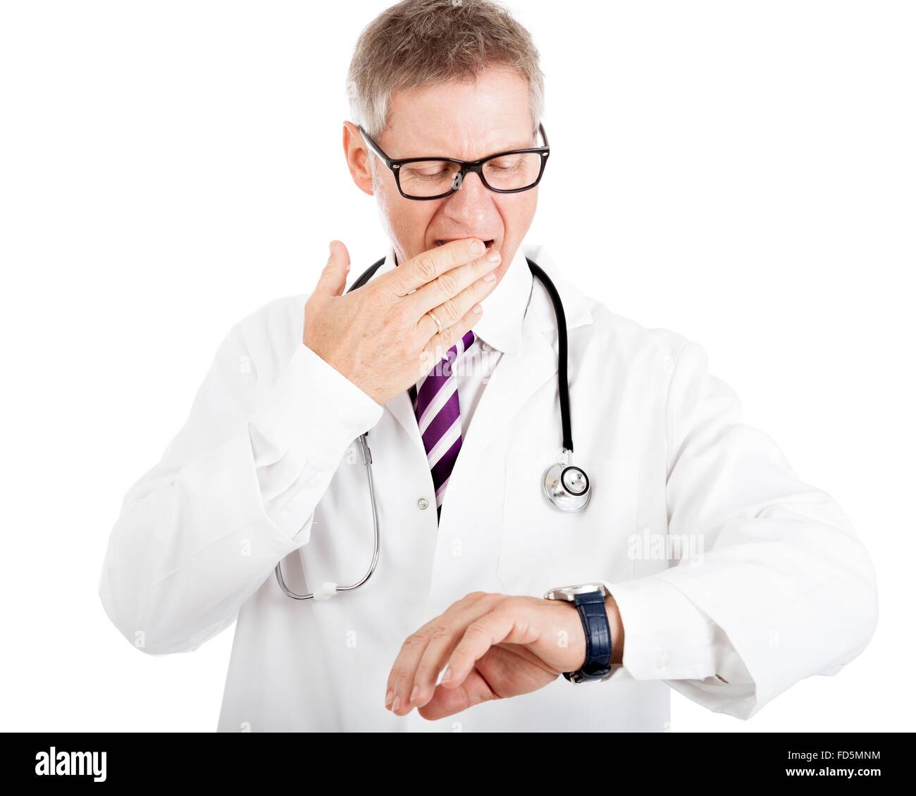 Di mezza età medico maschio gesticolando presso il suo orologio come egli controlla il tempo rimanente prima di un appuntamento o di una riunione, isolato Foto Stock