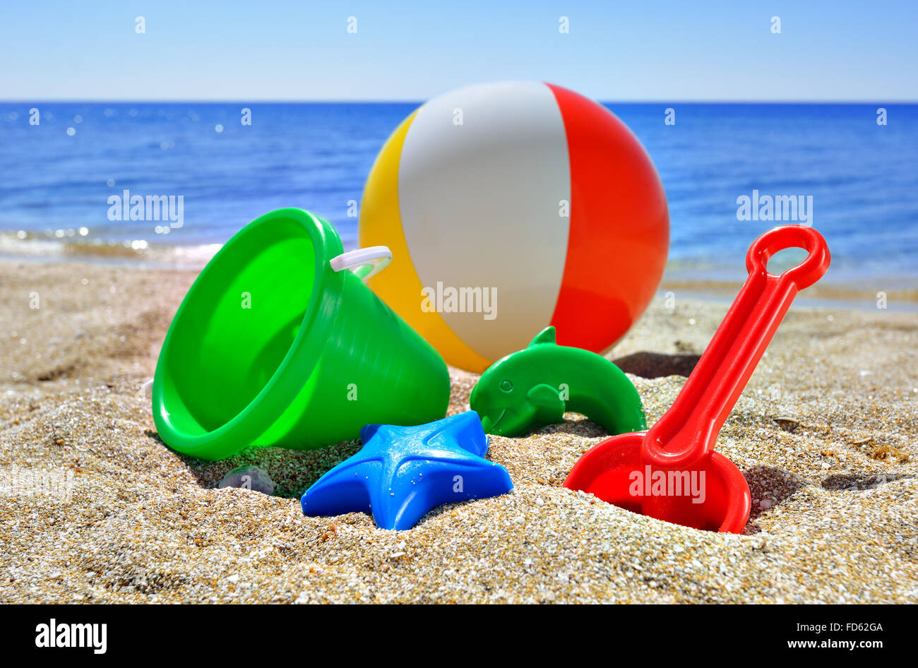 Giocattoli per bambini sulla spiaggia contro il blu del mare e del cielo  Foto stock - Alamy