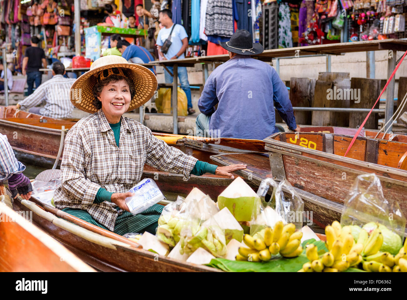 Un vendite merchant la sua merce al Mercato Galleggiante di Damnoen Saduak al di fuori di Bangkok. Foto Stock