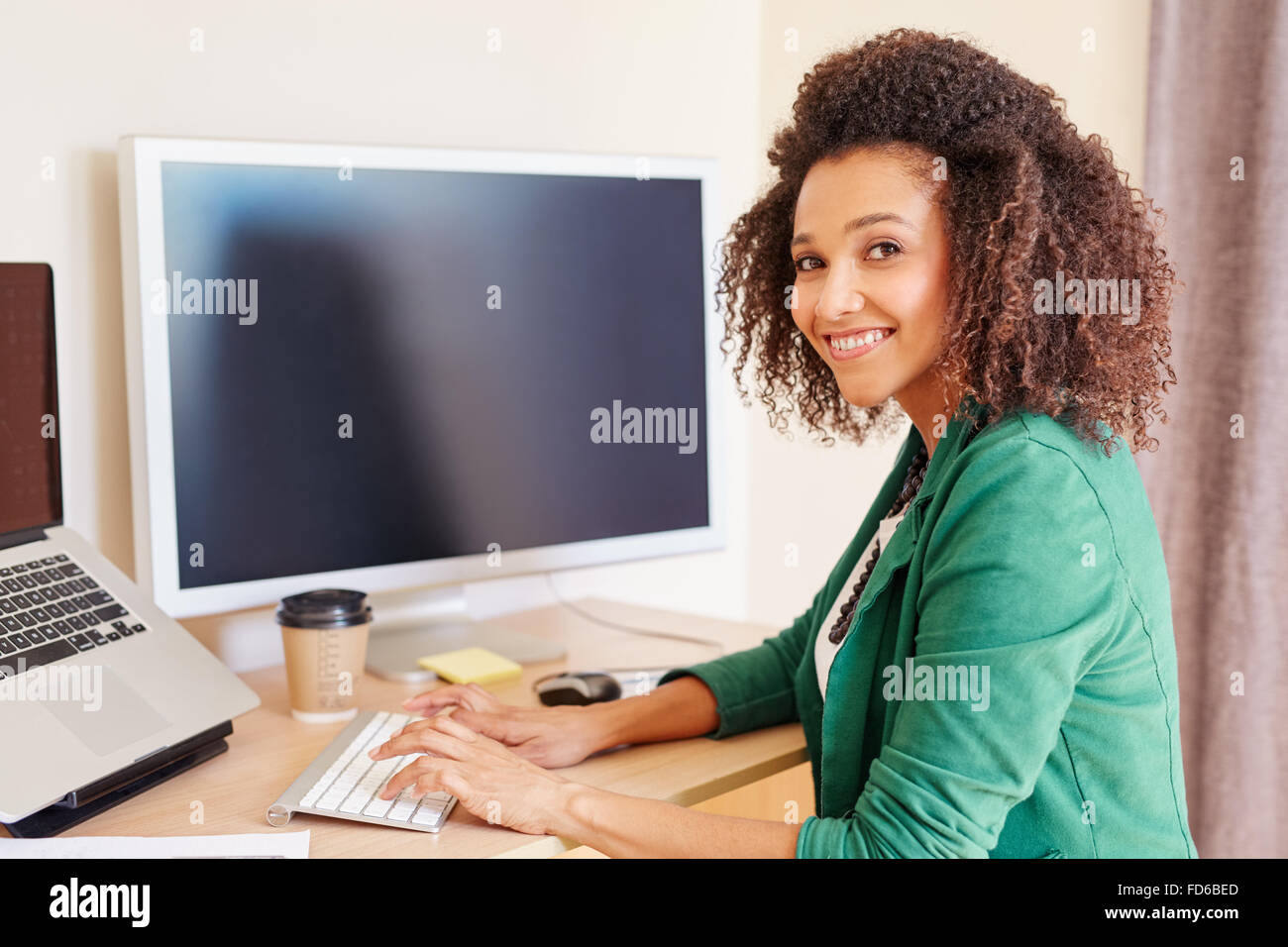 Razza mista imprenditrice digitazione sul computer alla sua scrivania Foto Stock