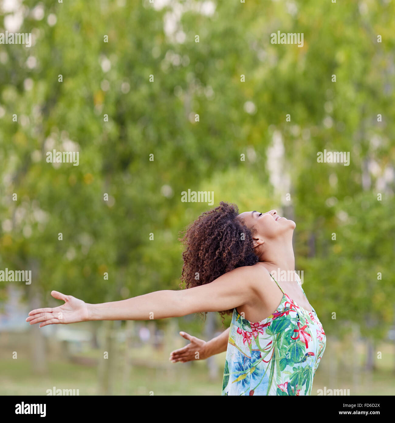 Donna con un'acconciatura afro sentirsi liberi in un parco Foto Stock