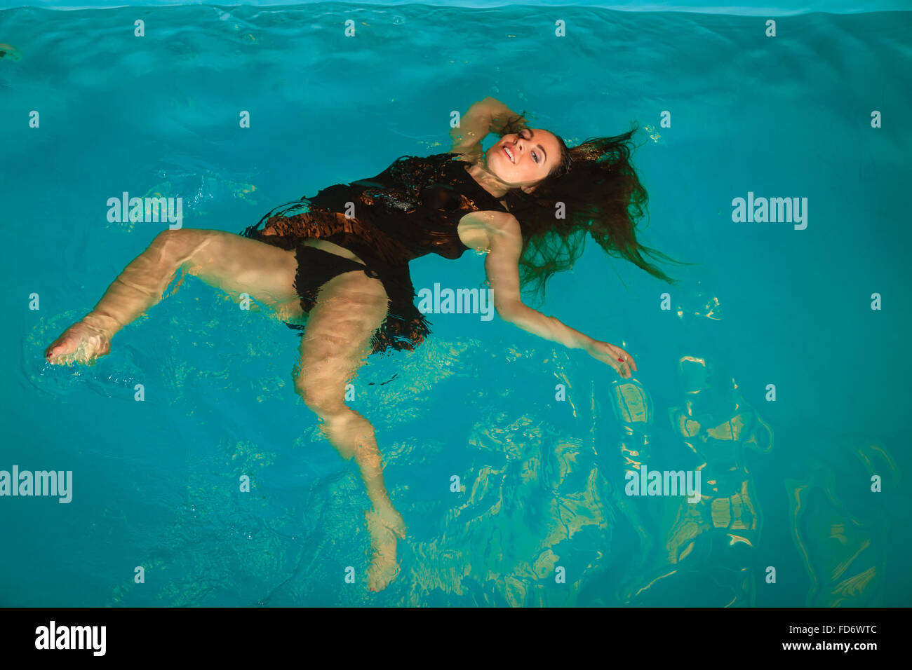 Donna di relax presso la piscina. Giovane ragazza vestita di nero vestito  flottanti. Aerobica in acqua fitness Foto stock - Alamy