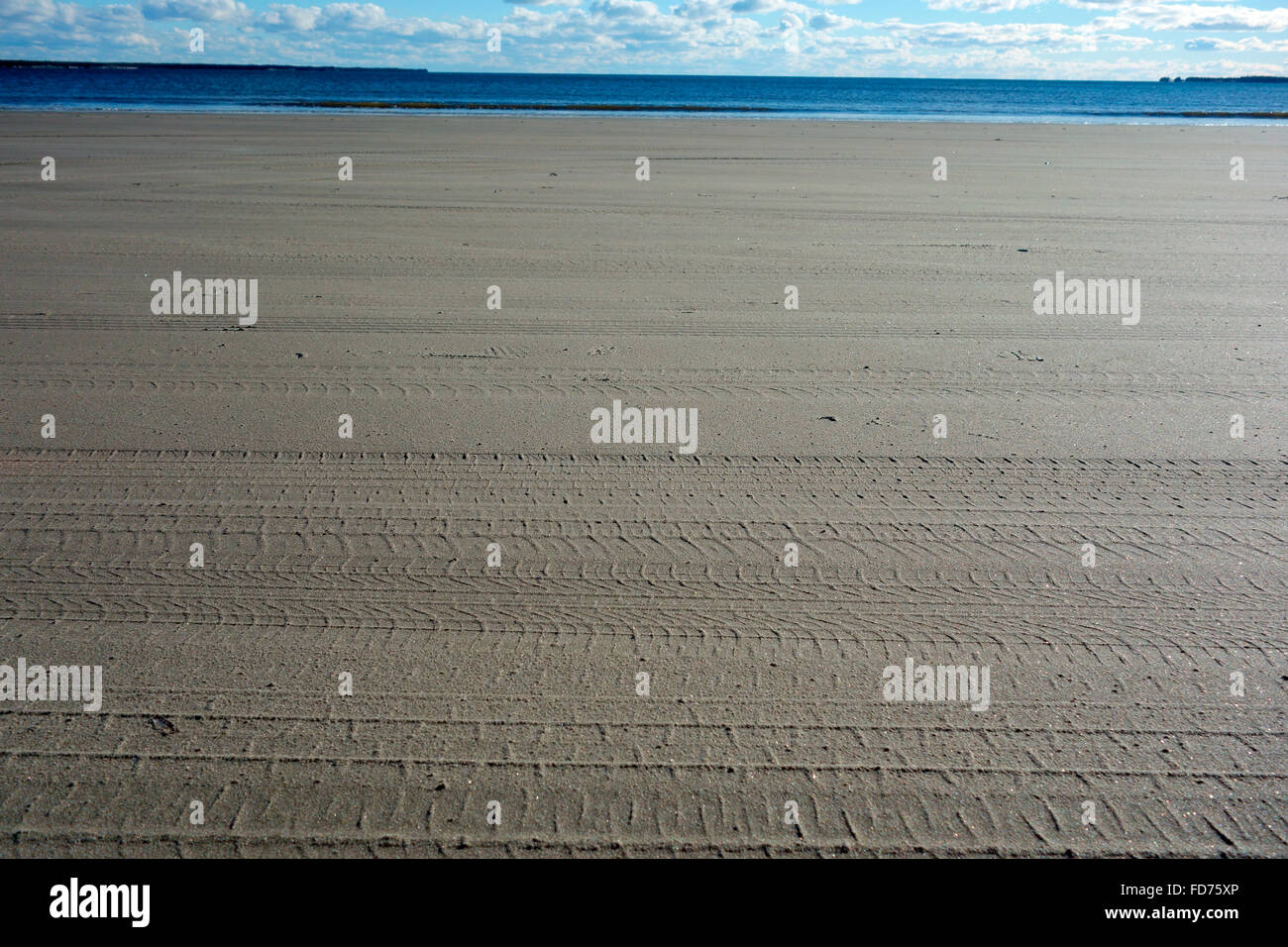 Tracce di pneumatici sulla sabbia di una spiaggia da parte di un veicolo Foto Stock