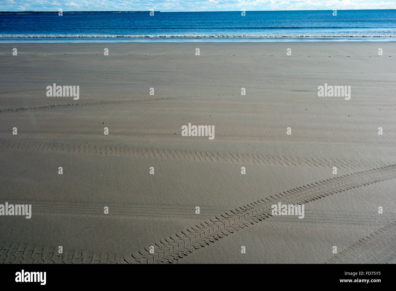 Tracce di pneumatici sulla sabbia di una spiaggia da parte di un veicolo Foto Stock