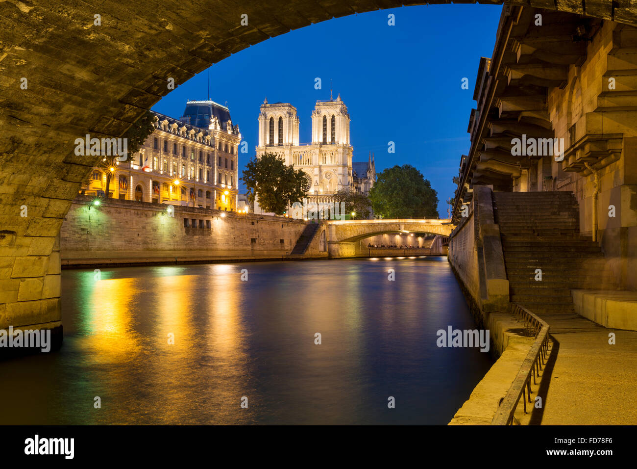 Twilight sotto Pont Saint Michel con la cattedrale di Notre Dame e il Fiume Senna e PREFECTURE DE POLICE DI PARIGI, FRANCIA Foto Stock