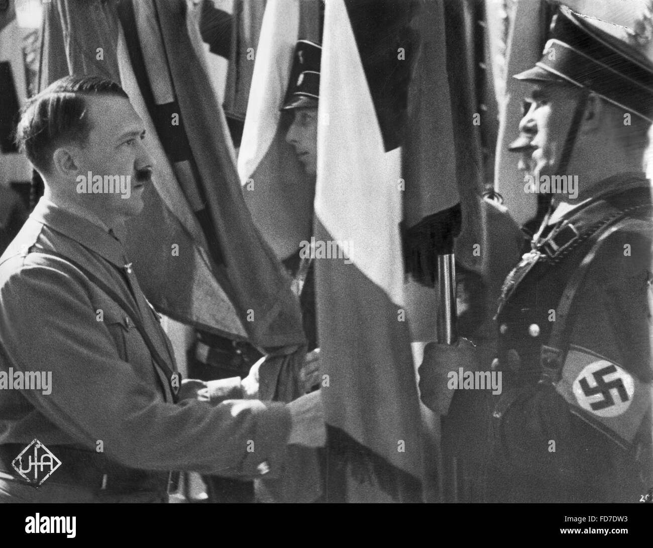 Adolf Hitler in occasione di una cerimonia che si terrà in cui nuove bandiere erano consacrate dal sangue bandiera al Rally di Norimberga nel 1934 e nel Foto Stock