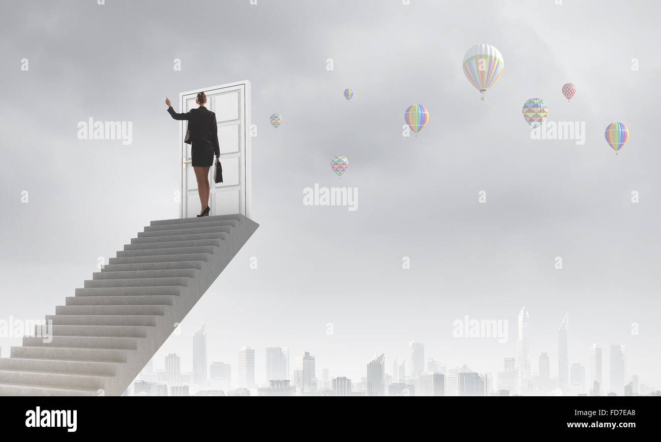 Imprenditrice a piedi fino alla scalinata porta in cielo Foto Stock