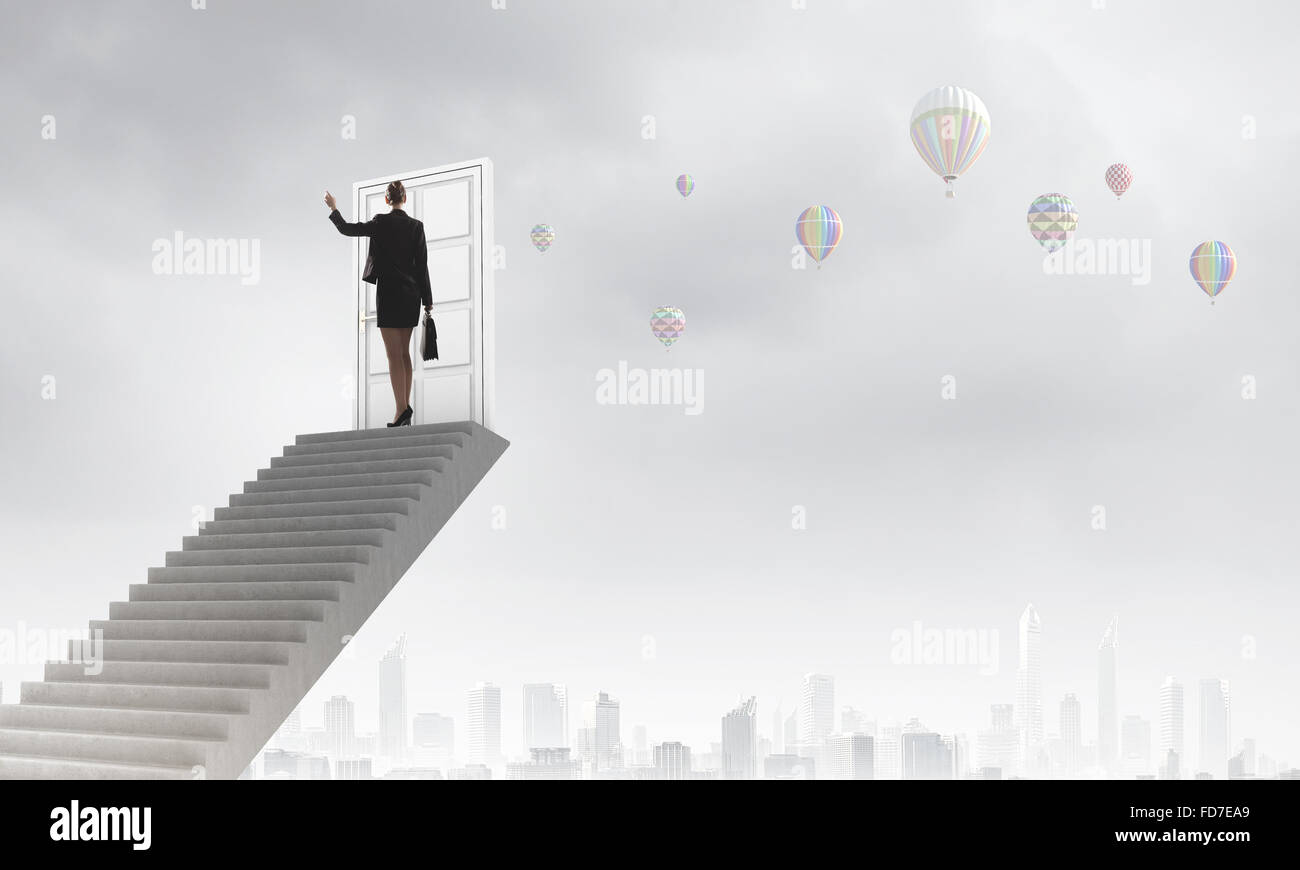 Imprenditrice a piedi fino alla scalinata porta in cielo Foto Stock