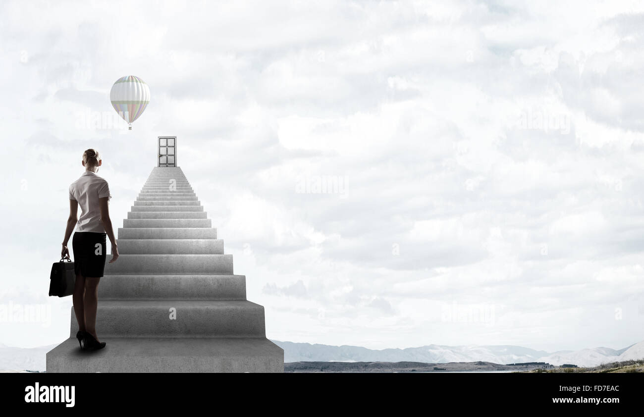 Imprenditrice a piedi fino alla scalinata porta in cielo Foto Stock