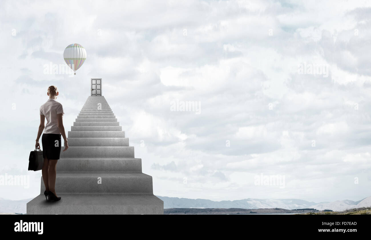 Imprenditrice a piedi fino alla scalinata porta in cielo Foto Stock