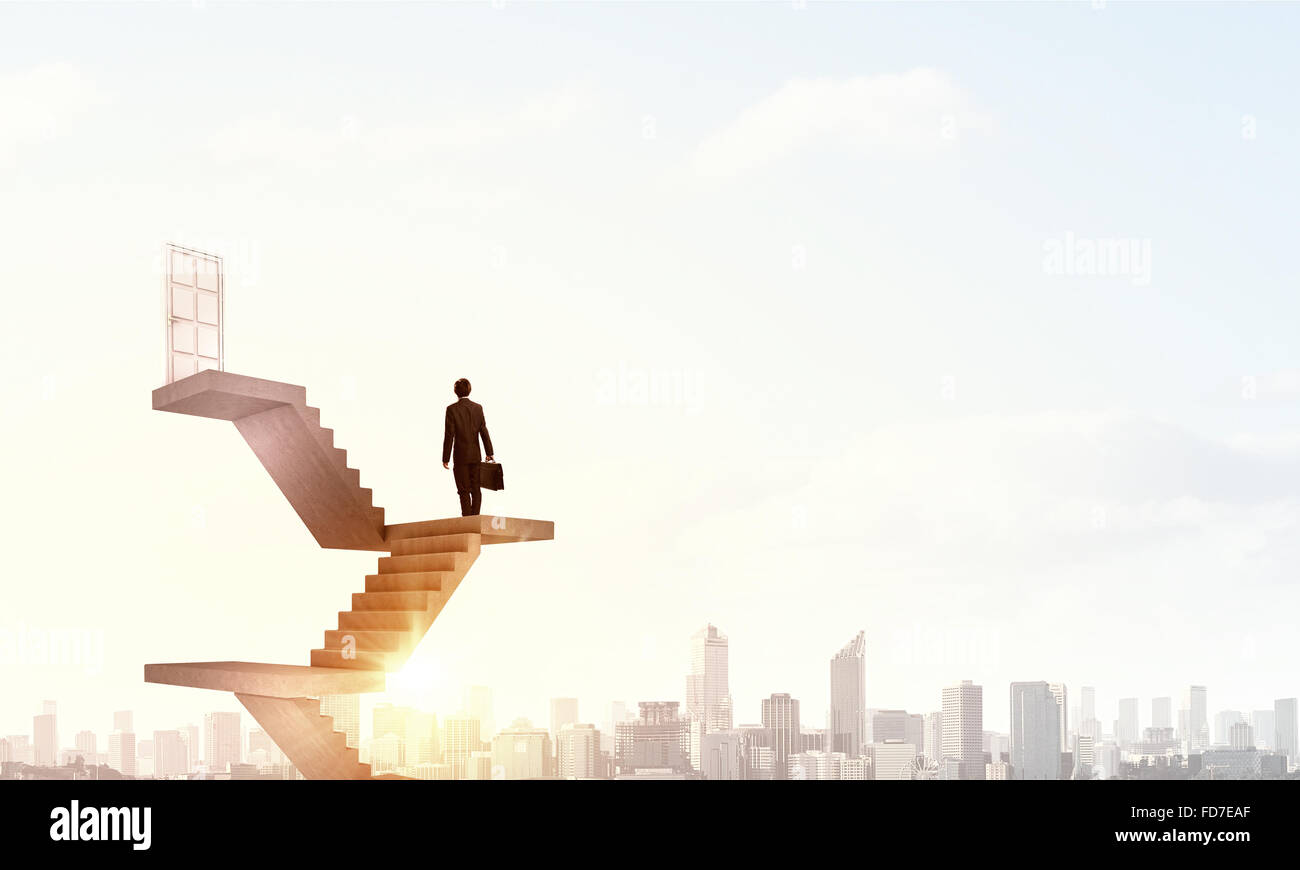 Imprenditore a piedi fino alla scalinata porta in cielo Foto Stock