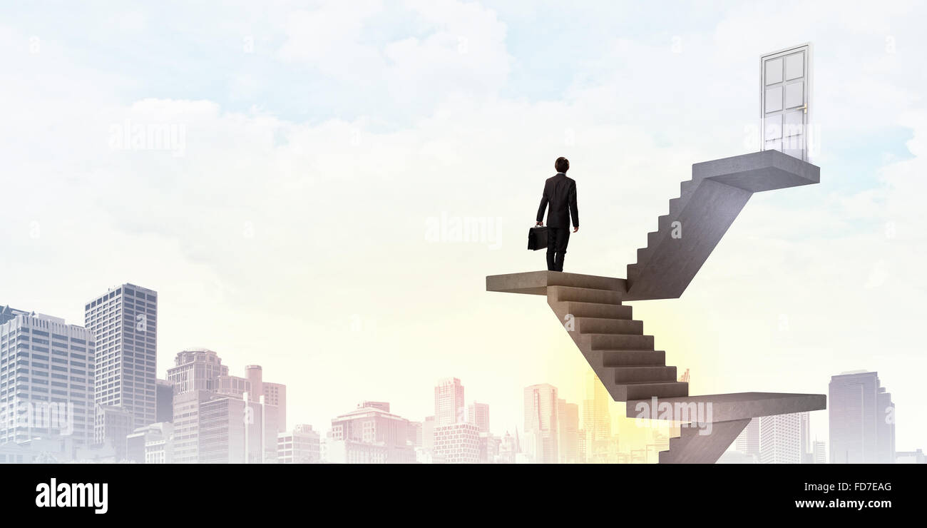 Imprenditore a piedi fino alla scalinata porta in cielo Foto Stock