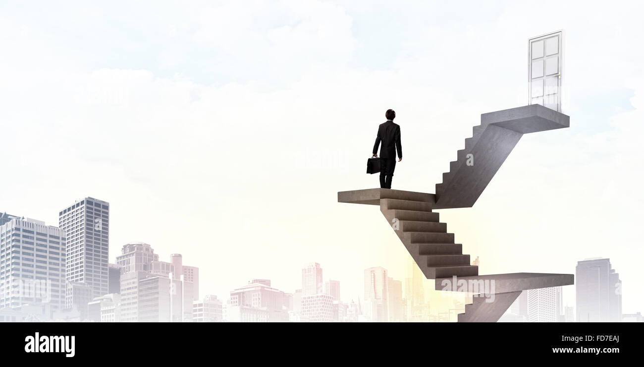 Imprenditore a piedi fino alla scalinata porta in cielo Foto Stock