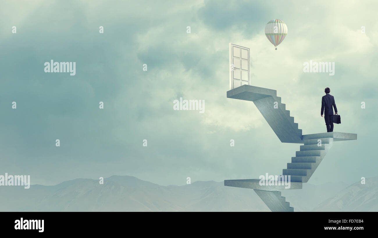 Imprenditore a piedi fino alla scalinata porta in cielo Foto Stock