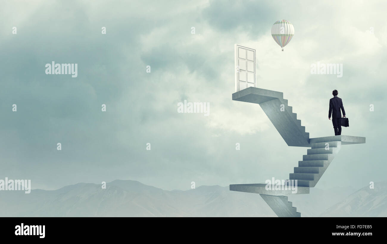 Imprenditore a piedi fino alla scalinata porta in cielo Foto Stock