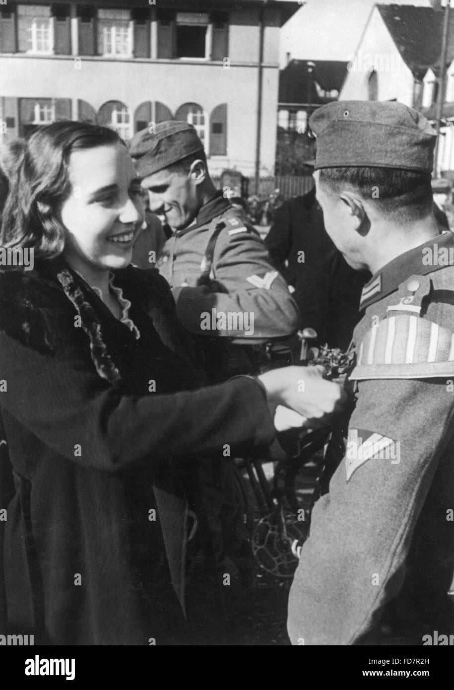 Ragazza dà ai fiori di soldati Foto Stock