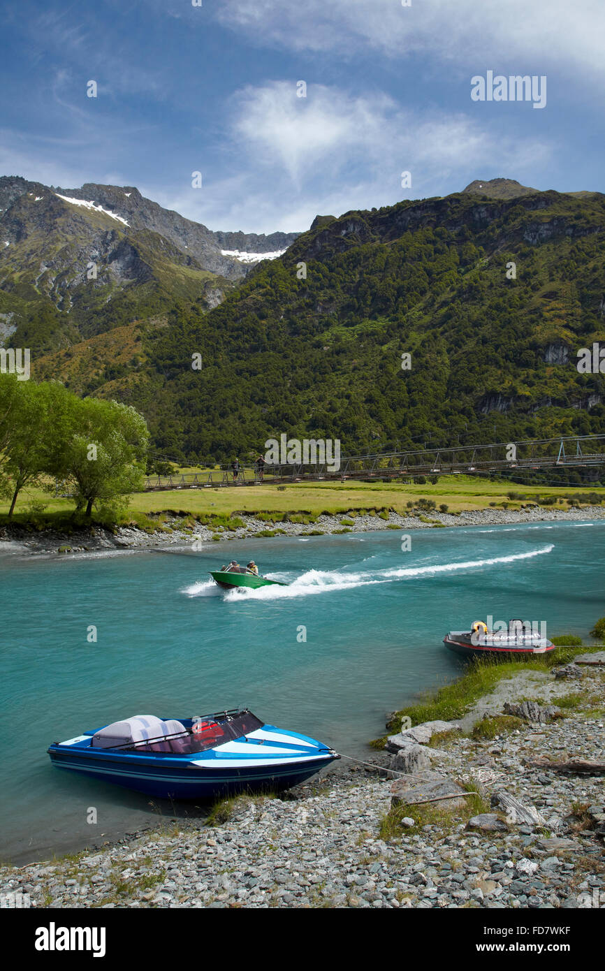 Barche Jet e persone sulla sospensione ponte sul fiume Matukituki ramo Ovest, Matukituki Valley, vicino a Wanaka, Otago, Isola del Sud Foto Stock