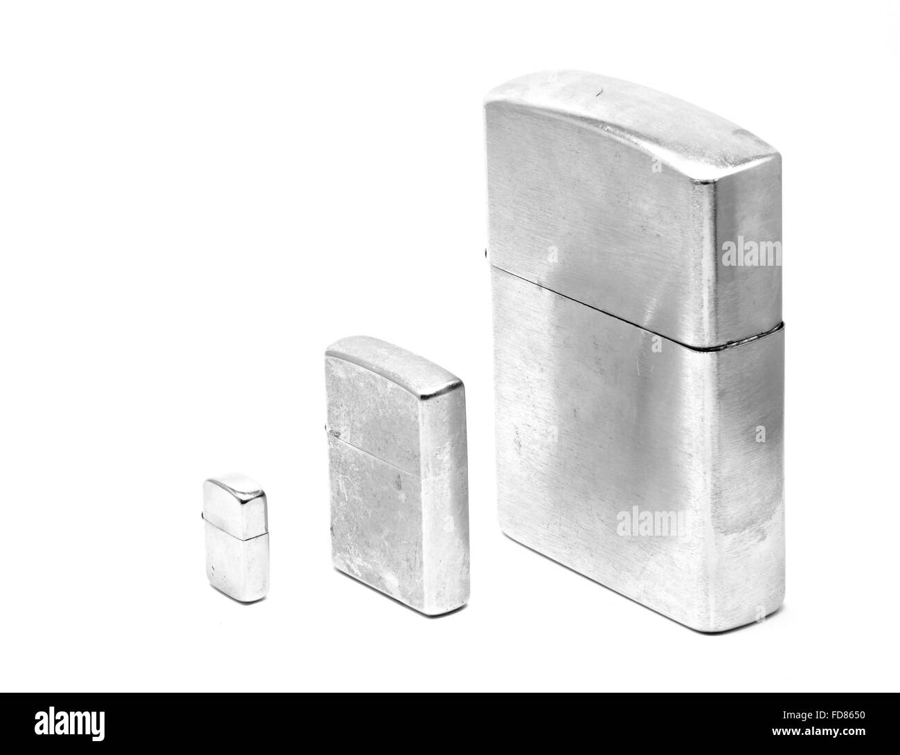 Tre differenti dimensioni di accendini metallico con tappo chiuso Foto Stock