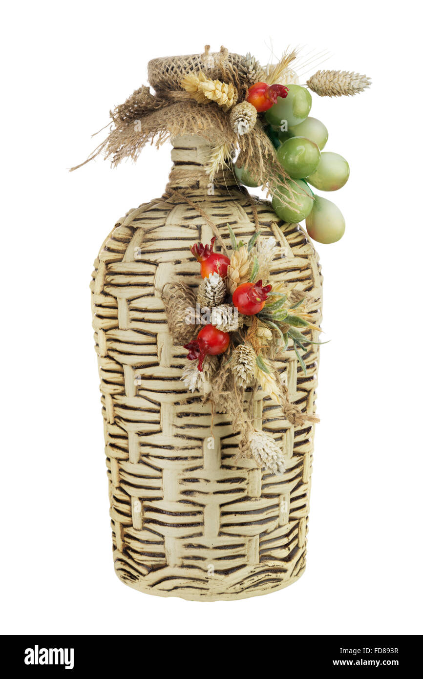 Vecchia bottiglia di vino decorato con una composizione di spighe di grano, uva e foglie isolati su sfondo bianco. Foto Stock