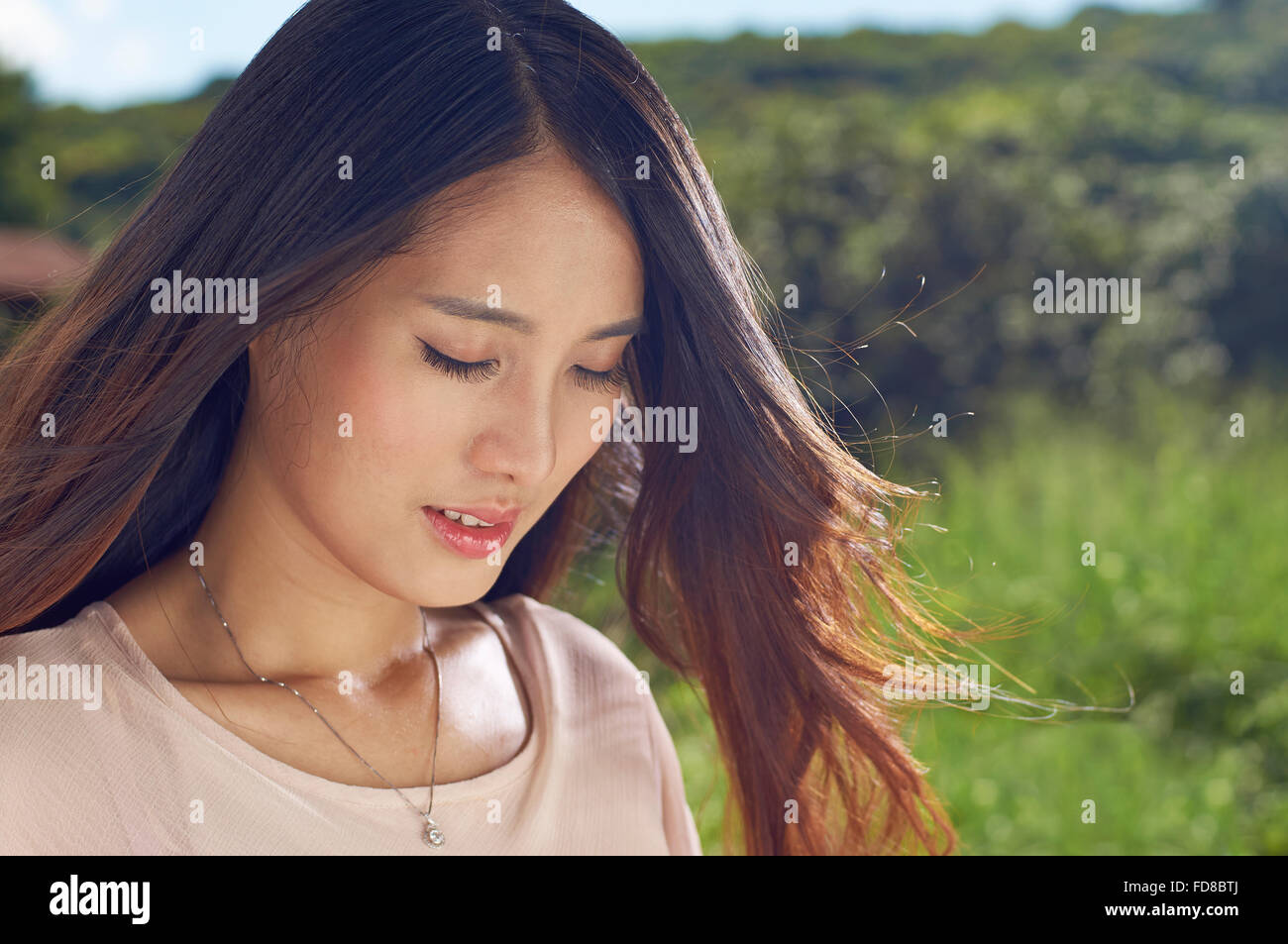 I giovani cinesi bellezza sorridente in natura con gli occhi chiusi Foto Stock