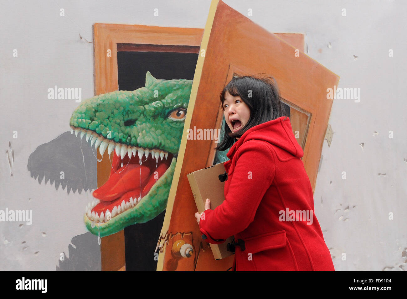 Chongqing Cina. 29 gen, 2016. Una donna pone con la tecnica del trompe-l'oeil a Sanxia piazza di Chongqing, a sud-ovest della Cina, 29 gennaio, 2016. Trompe-l'oeil è una tecnica che utilizza immagini realistiche per creare l'illusione ottica che oggetti rappresentati esistono in tre dimensioni. © Tang Yi/Xinhua/Alamy Live News Foto Stock