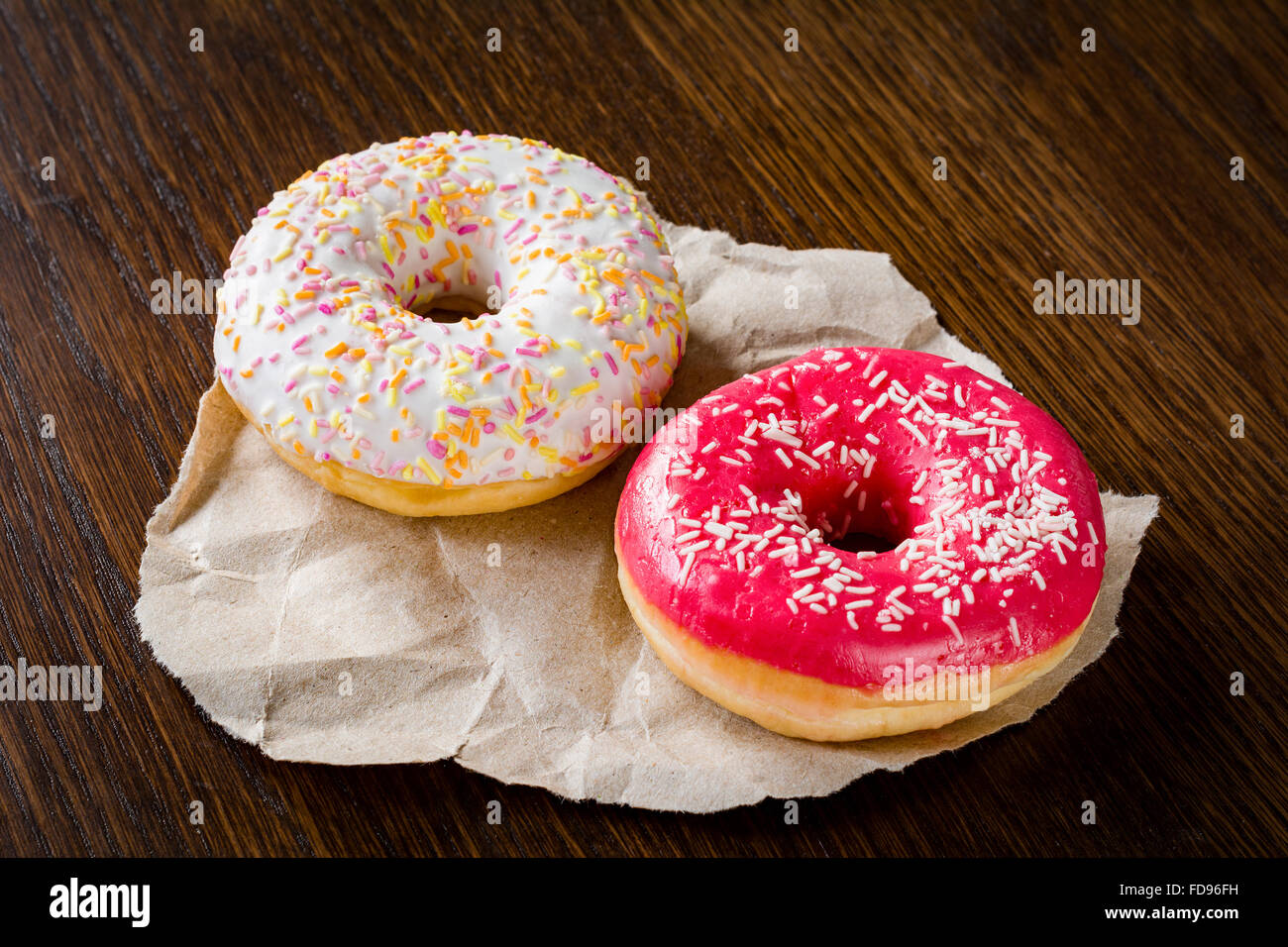 Due ciambelle su uno sfondo di legno Foto Stock
