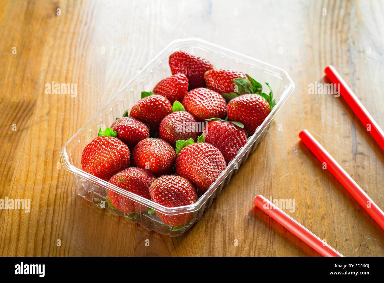 Scatola di fragole fresche su uno sfondo di legno Foto Stock