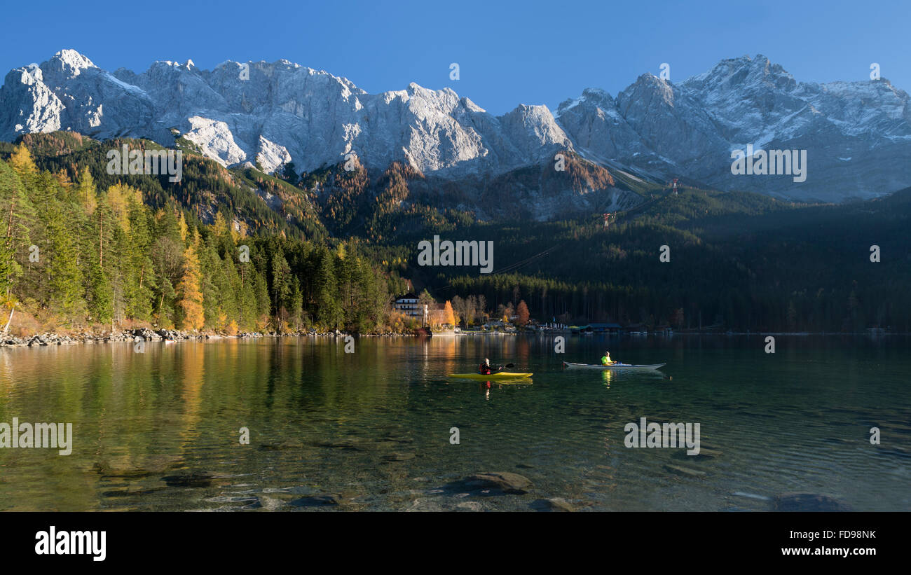 Paesaggio autunnale con kayakers sul lago Eibsee nella parte anteriore del Wetterstein gamma di montagna con il Monte Zugspitze, Baviera, Germania Foto Stock