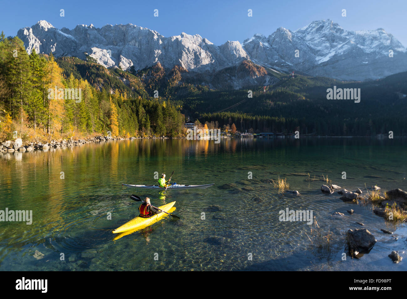 Paesaggio autunnale con kayakers sul lago Eibsee nella parte anteriore del Wetterstein gamma di montagna con il Monte Zugspitze, Baviera, Germania Foto Stock