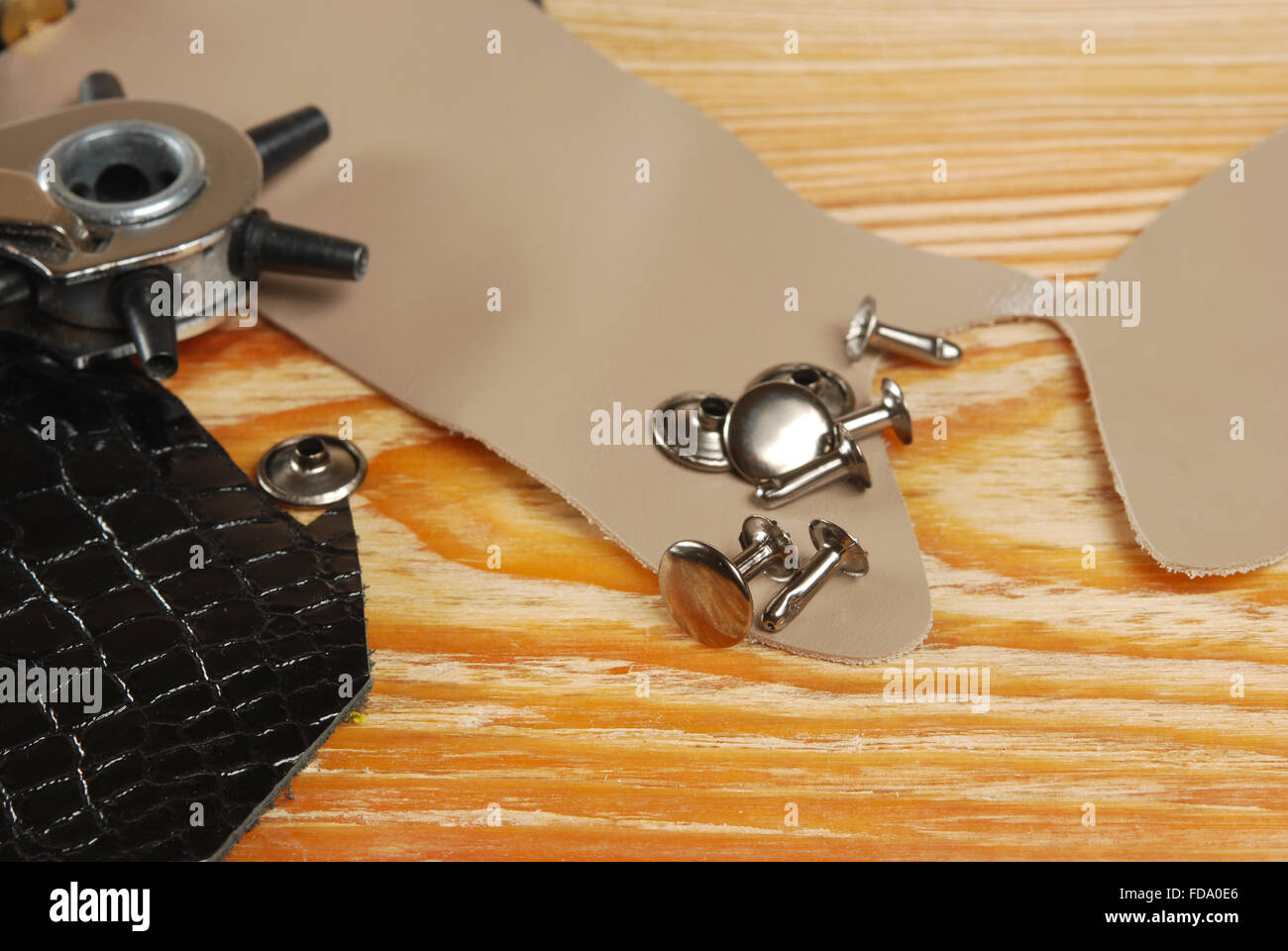 Luogo di lavoro sarto con pezzi di cuoio e strumento per la punzonatura di  fori e rivetti Foto stock - Alamy