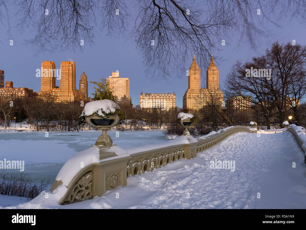 Central Park ponte di prua al lago e Upper West Side edifici all'alba su un freddo inverno mattina. La città di New York Foto Stock