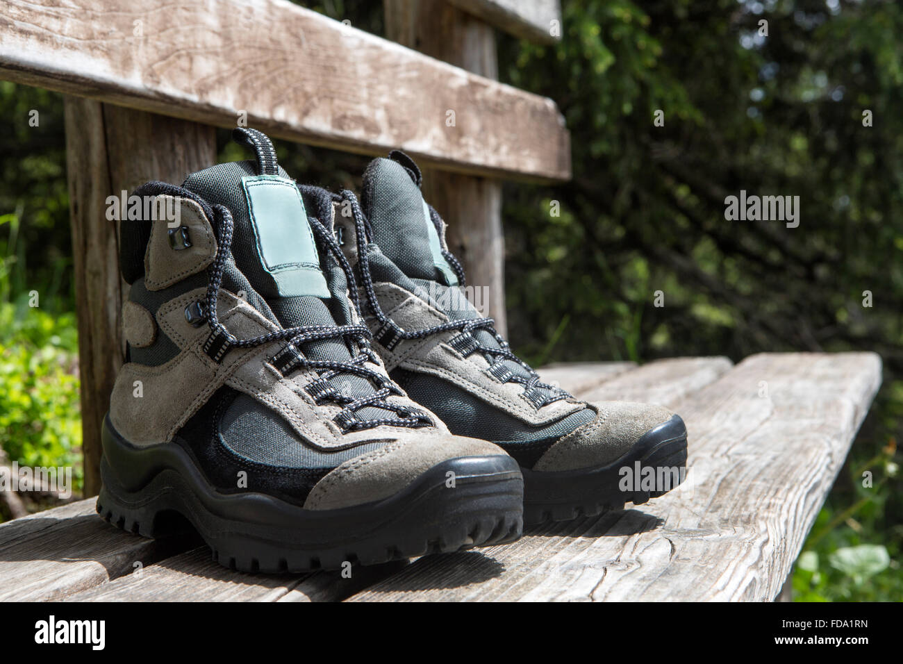 Grigio scarpe da escursionismo su un banco, estate Foto Stock