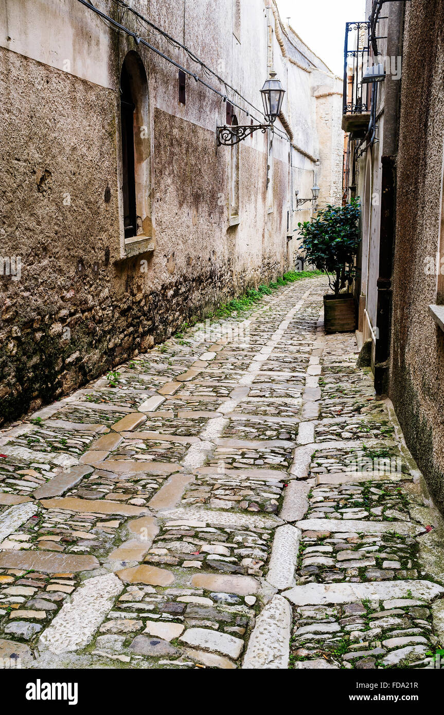 Strada di ciottoli e costruzione di esterni in Erice, città storica e comune in provincia di Trapani, Sicilia Foto Stock