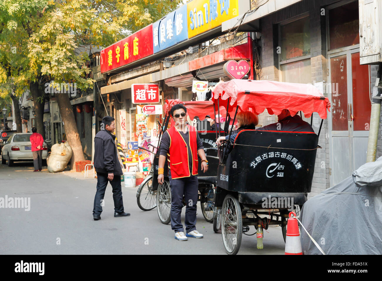 Il cinese rickshaw driver a fare la spesa per produrre in un mercato all'aperto nel centro di Pechino, Cina. Foto Stock