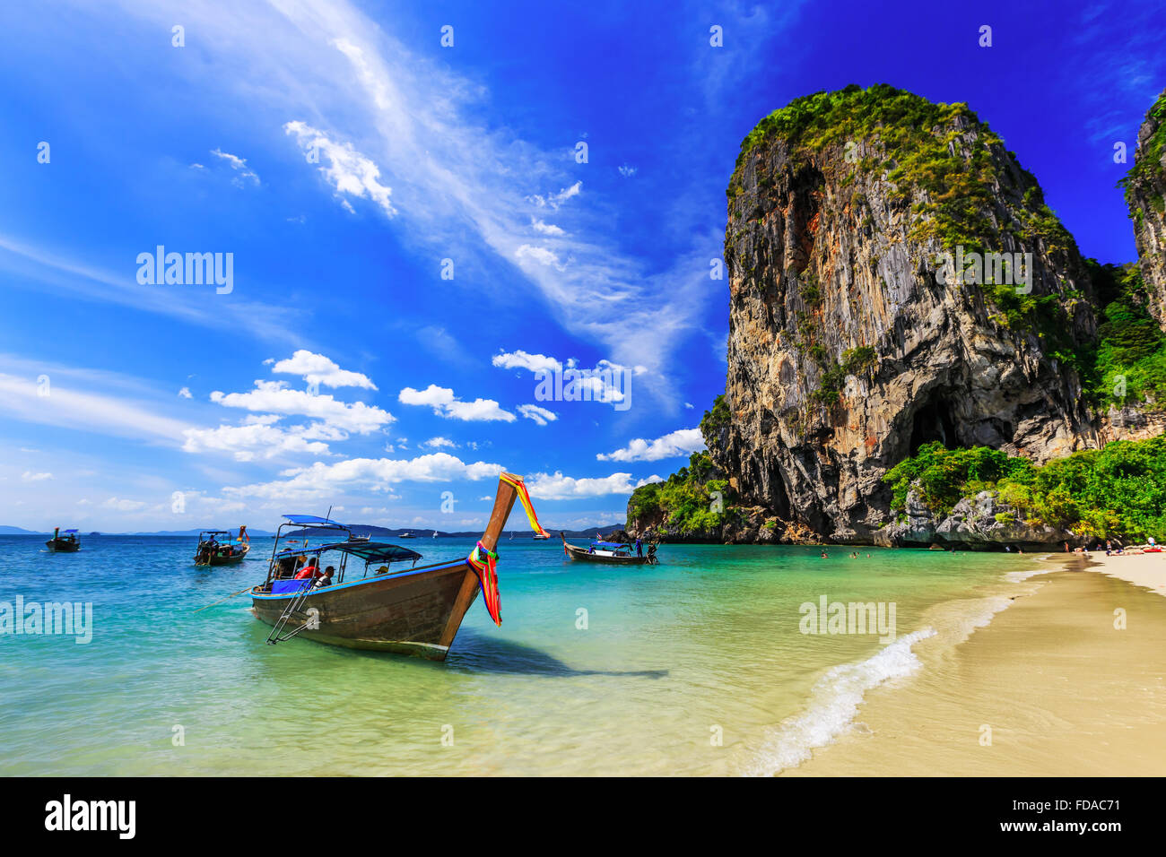 Thailandia, Krabi. Barca dalla coda lunga sulla spiaggia tropicale con roccia calcarea. Foto Stock