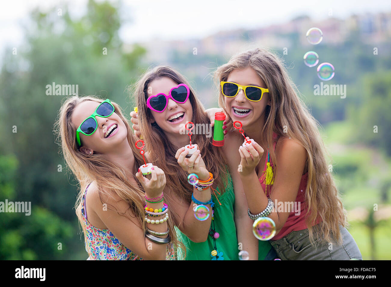Sorridenti gruppo di ragazze adolescenti a soffiare bolle Foto Stock