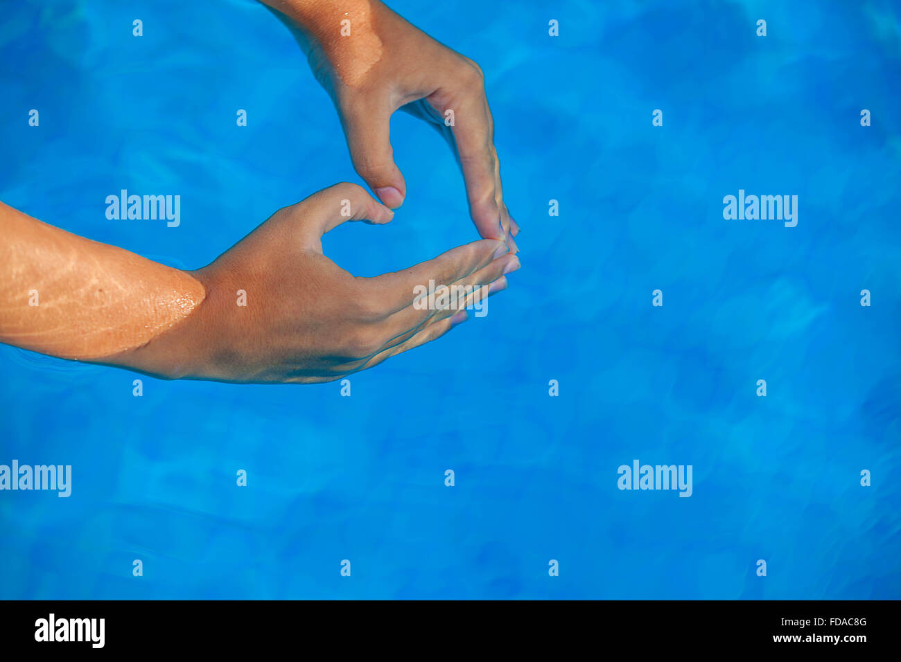 La vacanza estiva di amore a forma di cuore le mani in piscina. Foto Stock