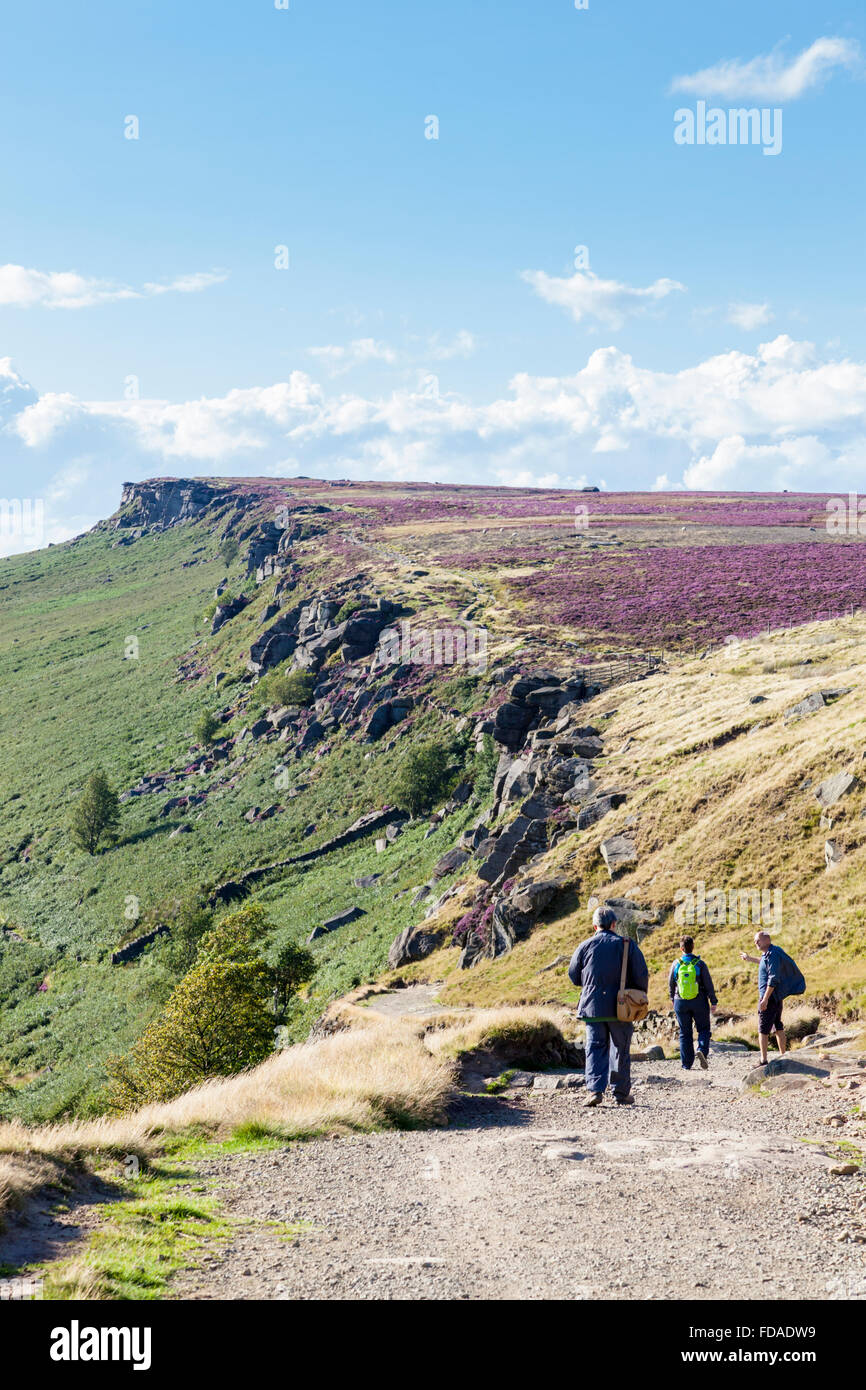 Walkers sulla lunga strada rialzata a bordo Stanage, una scarpata gritstone del Derbyshire Yorkshire border, Peak District, England, Regno Unito Foto Stock
