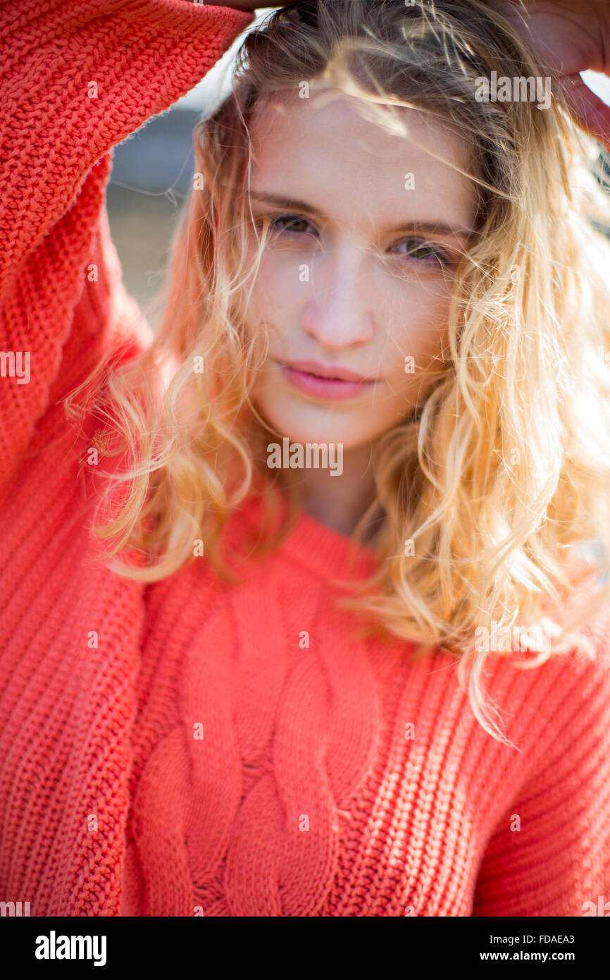 Ritratto di una giovane e bella donna presso la spiaggia. Guarda la fotocamera e di indossare un abbigliamento informale. Foto Stock