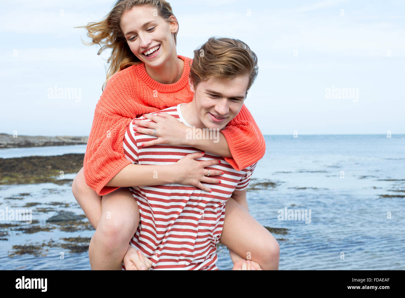 Bella coppia Giovane presso la spiaggia. Essi sono sorridente e la giovane donna sta avendo un piggyback dal suo fidanzato. Foto Stock