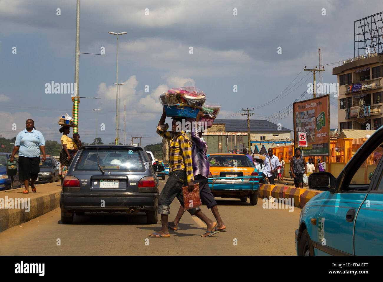 Scena urbana di Lagos, con molte persone di negoziazione, che trasportano merci sopra la testa Foto Stock